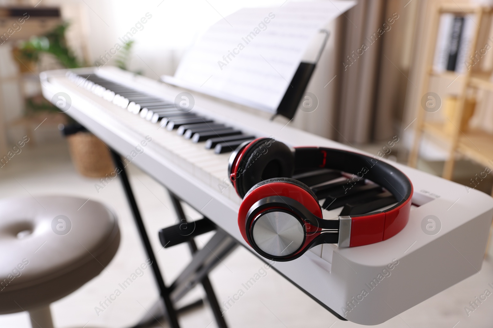 Photo of Synthesizer with music sheet and headphones indoors, closeup