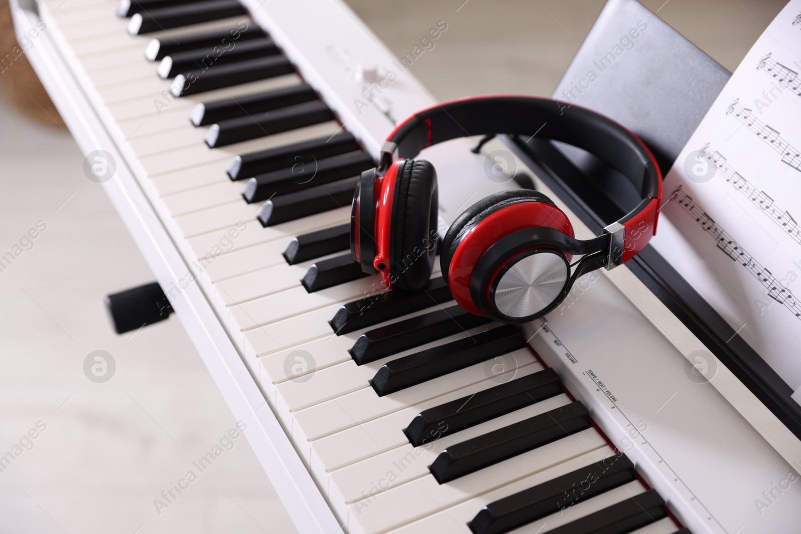 Photo of Synthesizer with music sheet and headphones indoors, closeup