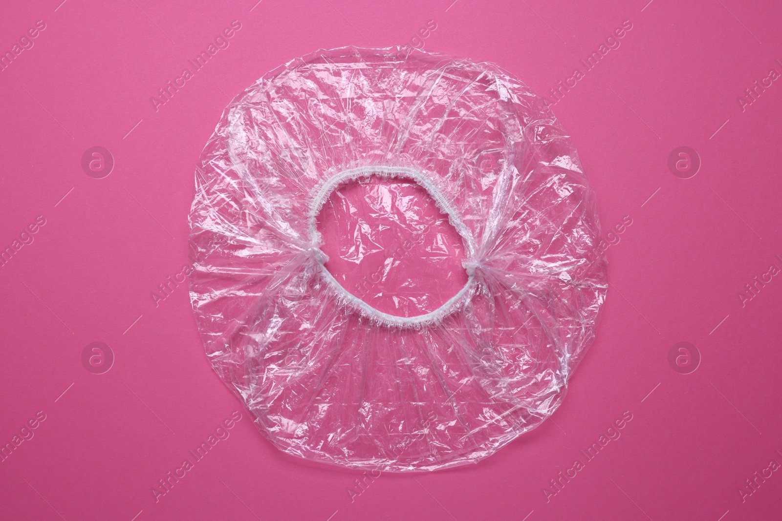 Photo of One shower cap on pink background, top view