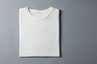 Photo of Blank white t-shirt on grey background, top view. Mockup for design