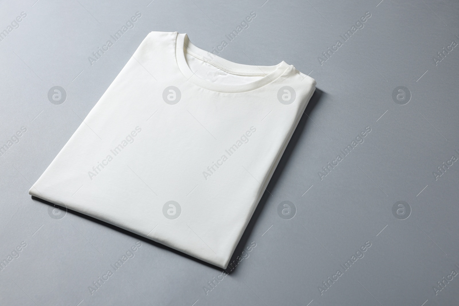 Photo of Blank white t-shirt on grey background. Mockup for design