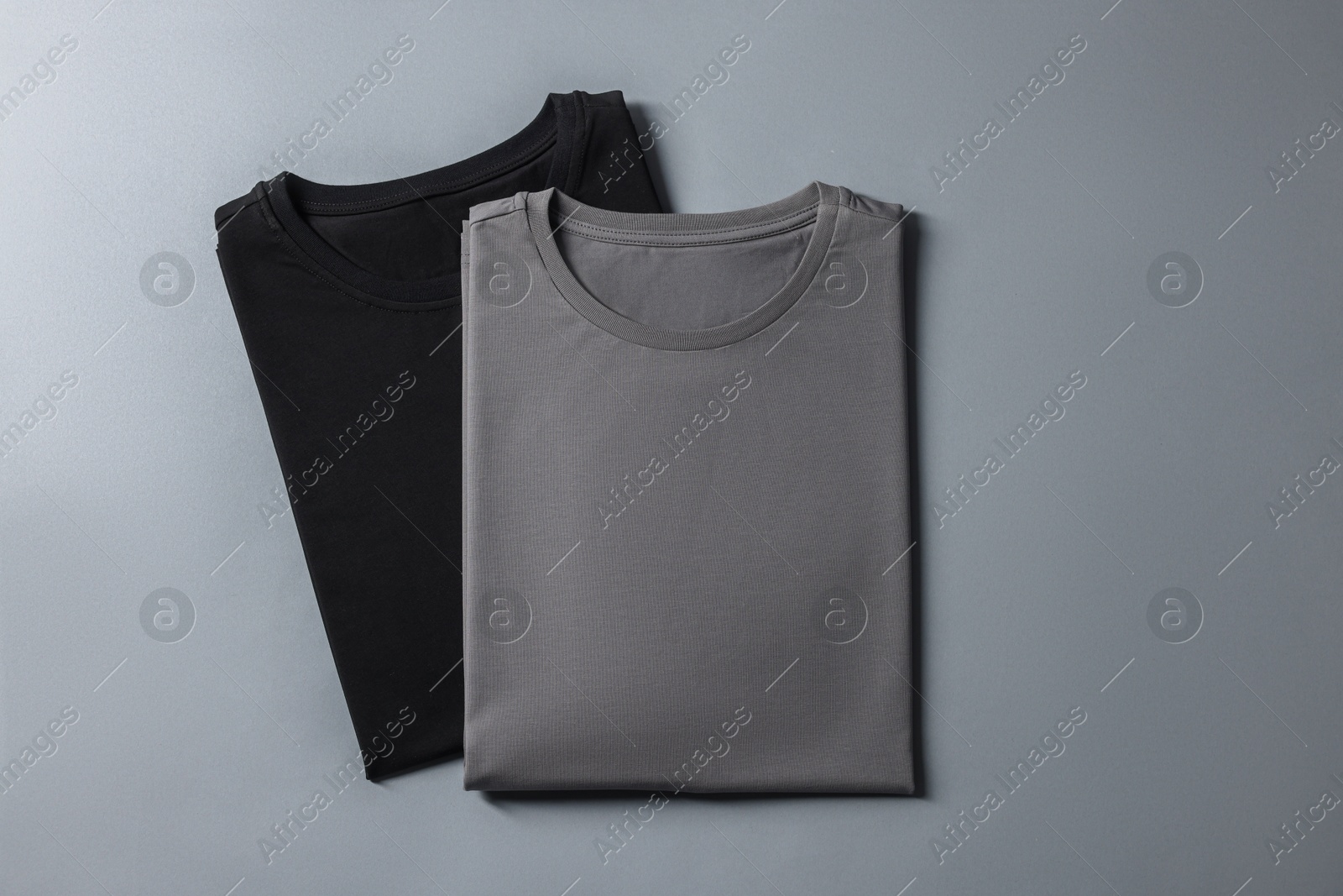 Photo of Different blank t-shirts on grey background, top view. Mockup for design