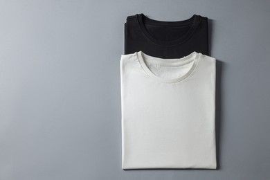 Photo of Different blank t-shirts on grey background, top view. Mockup for design