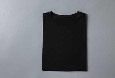 Photo of Blank black t-shirt on grey background, top view. Mockup for design