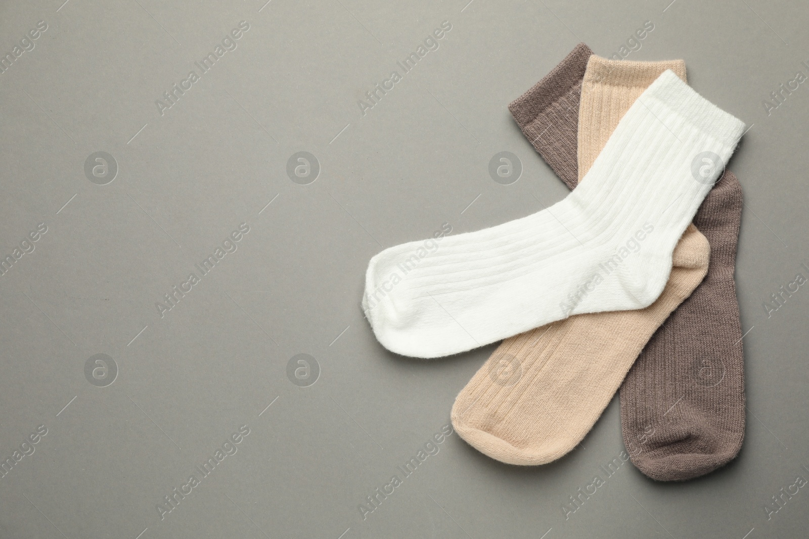 Photo of Different soft socks on light grey background, flat lay. Space for text