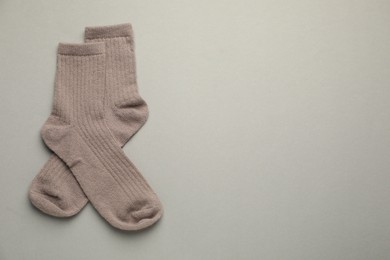 Photo of Pair of soft socks on light grey background, top view. Space for text