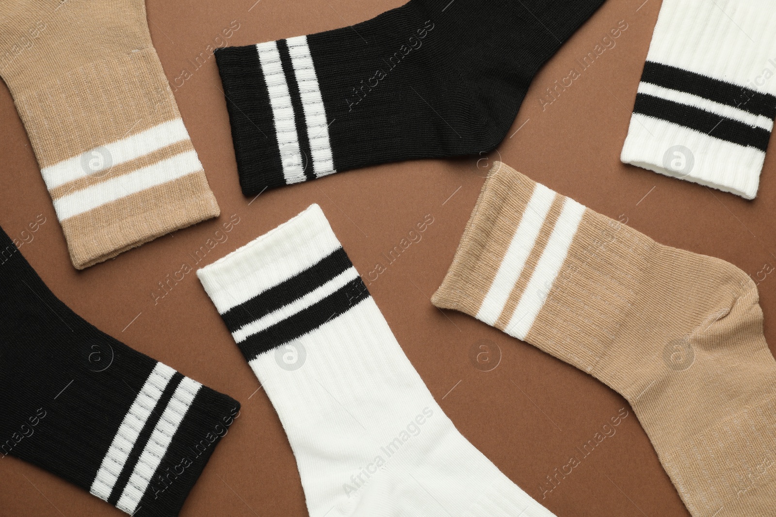 Photo of Different soft socks on light brown background, flat lay