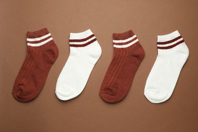 Photo of Different soft socks on light brown background, flat lay