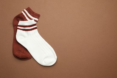 Photo of Pair of soft socks on light brown background, top view. Space for text