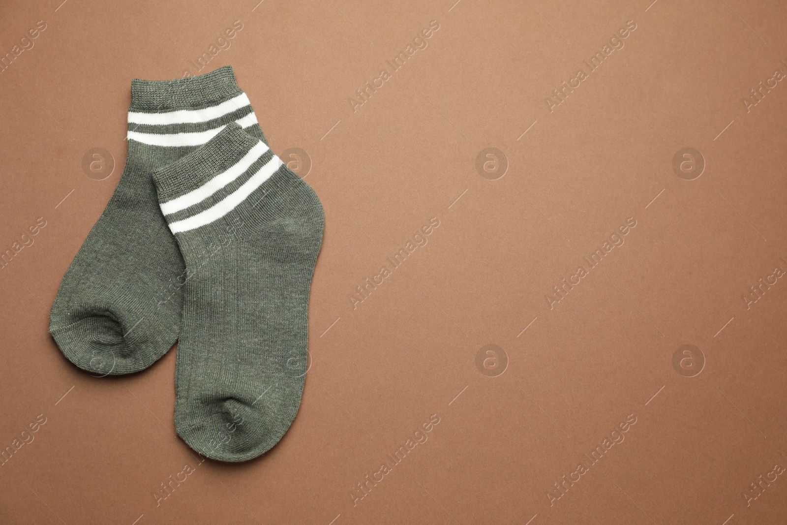 Photo of Pair of soft socks on light brown background, top view. Space for text