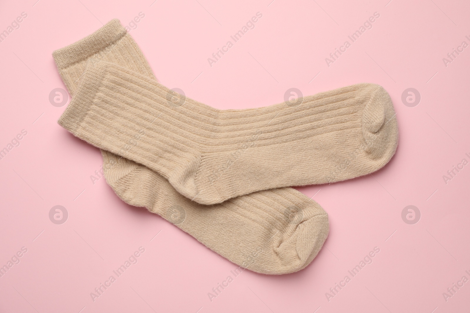 Photo of Pair of soft socks on pink background, top view