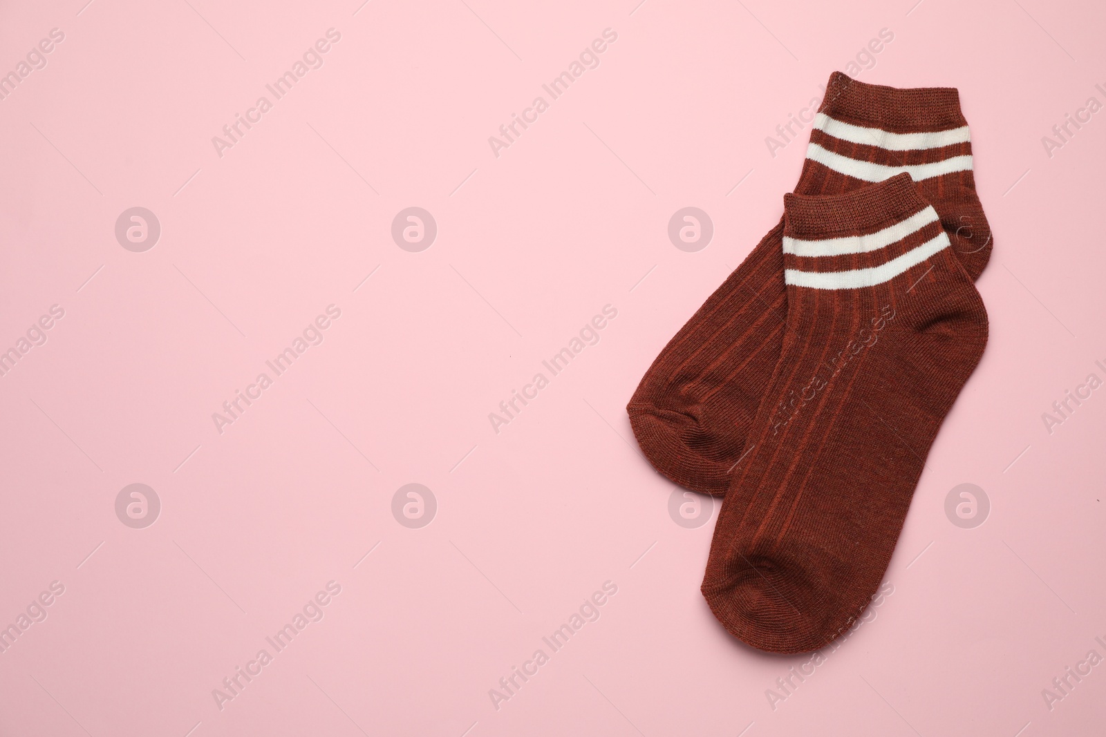 Photo of Pair of soft socks on pink background, top view. Space for text