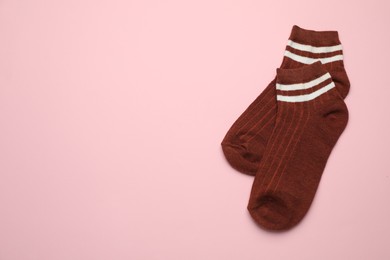 Photo of Pair of soft socks on pink background, top view. Space for text