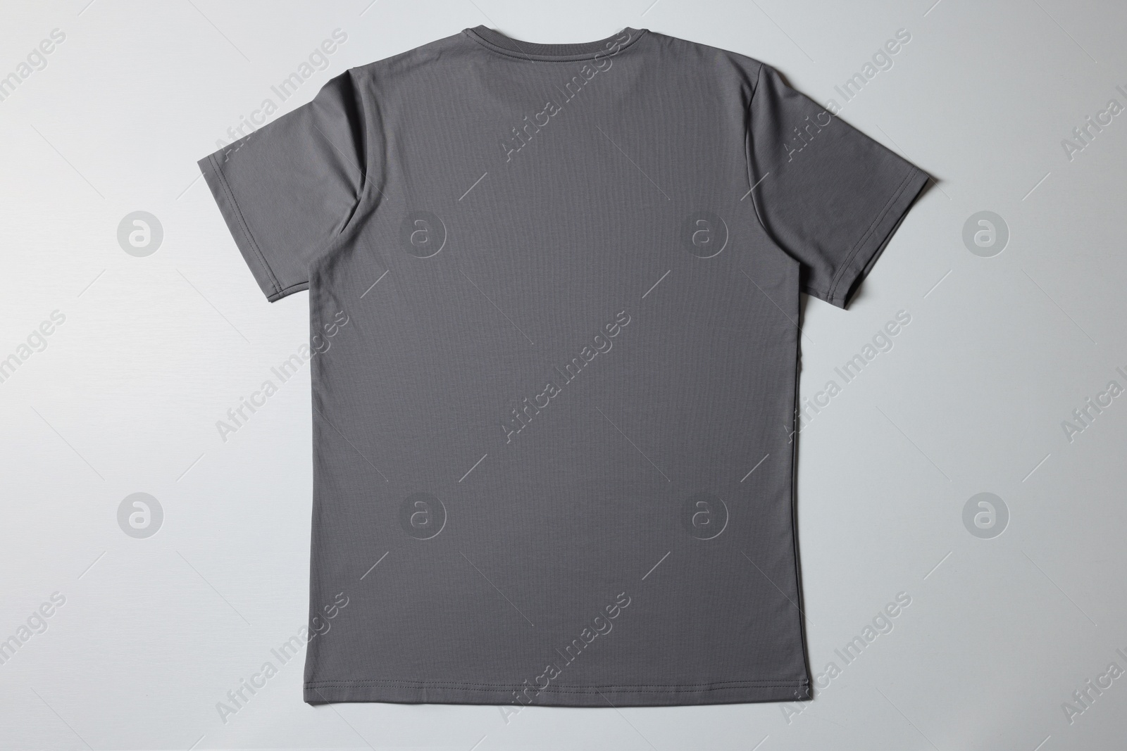 Photo of One blank t-shirt on white background, top view. Mockup for design