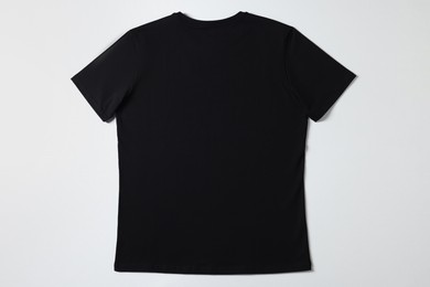 Photo of One blank t-shirt on white background, top view. Mockup for design