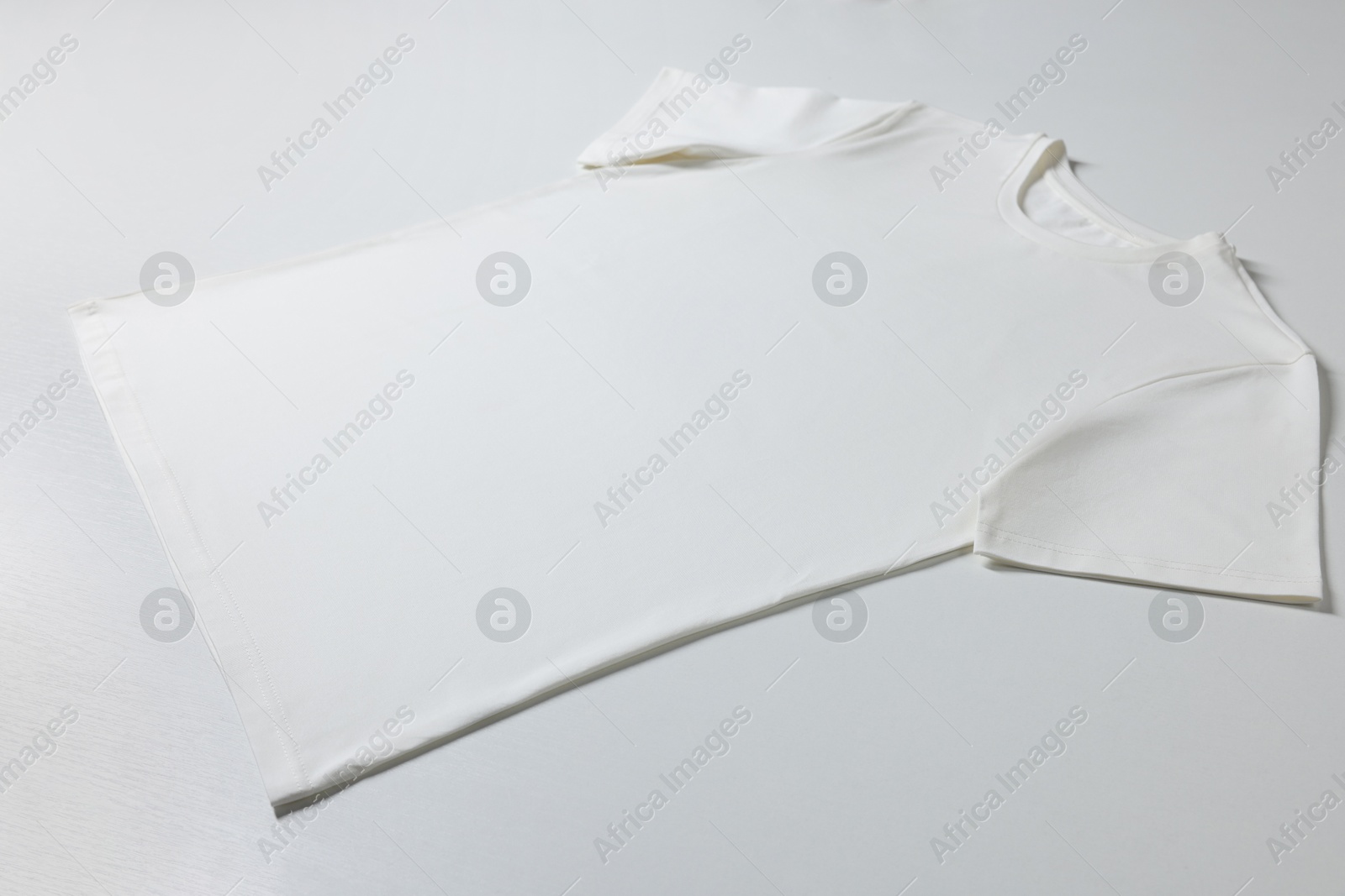 Photo of One blank t-shirt on white background. Mockup for design