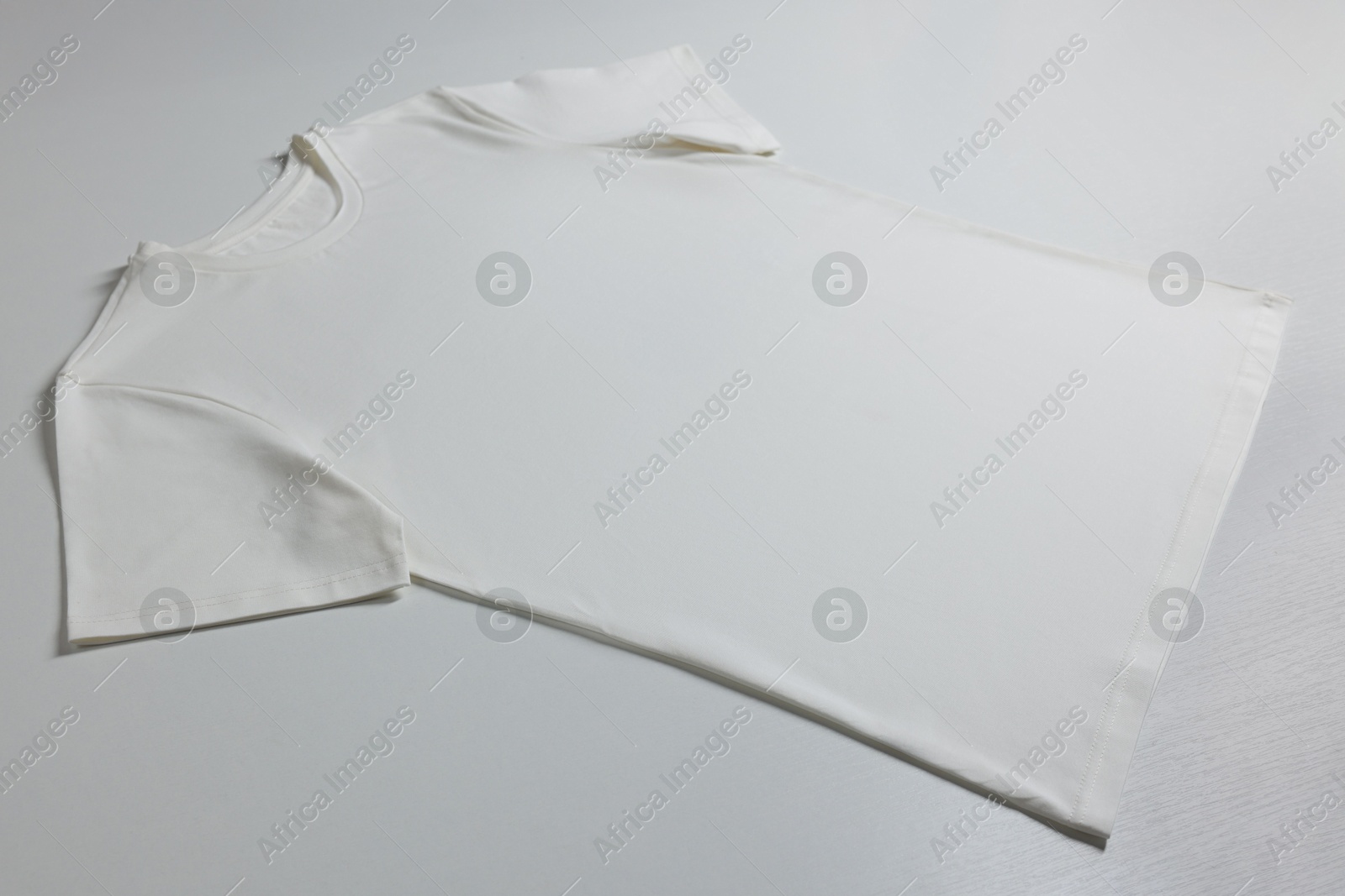 Photo of One blank t-shirt on white background. Mockup for design