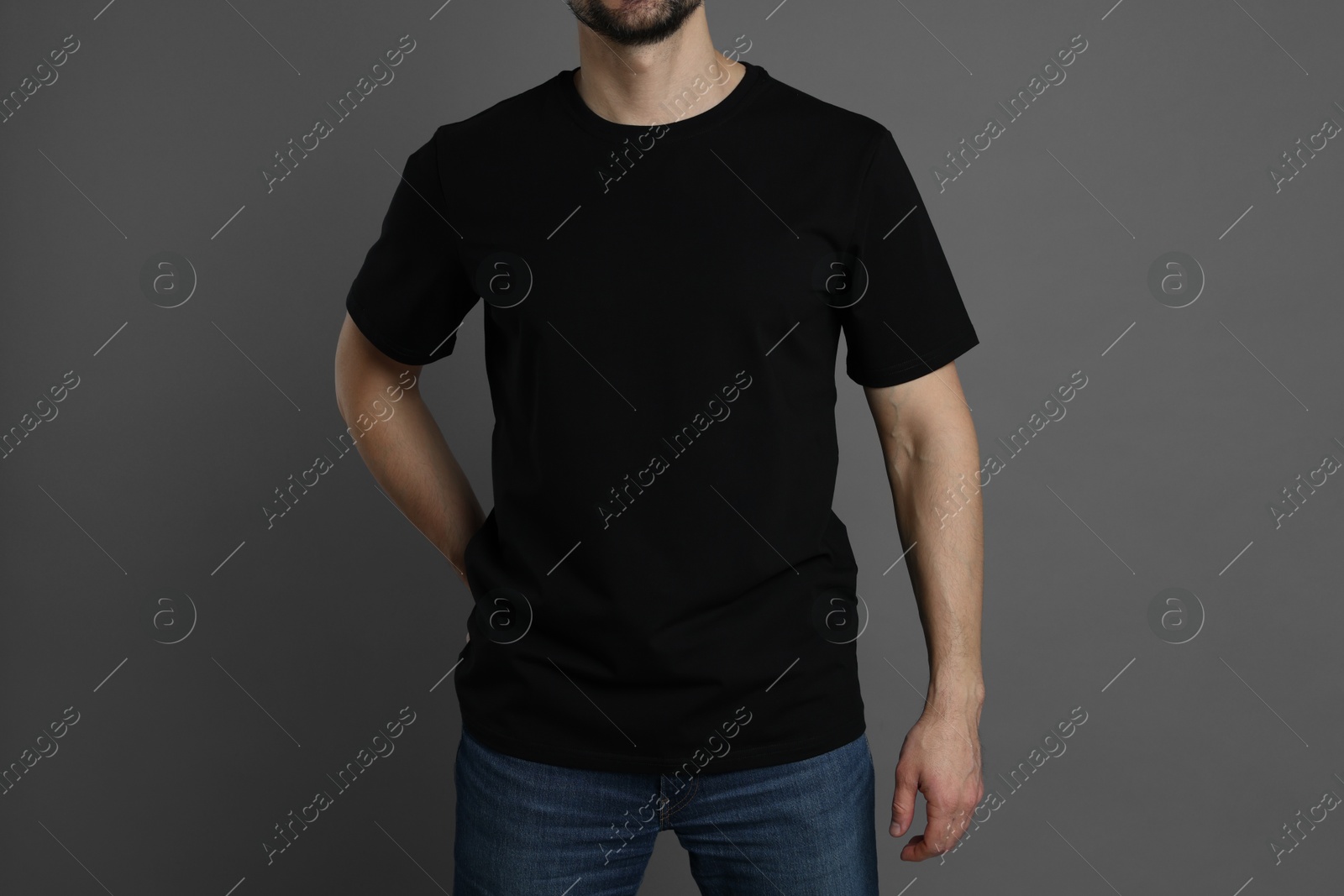 Photo of Man in blank black t-shirt on grey background, closeup. Mockup for design