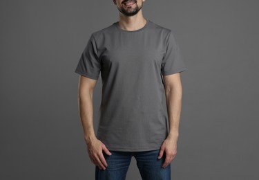 Photo of Man in blank t-shirt on grey background, closeup. Mockup for design