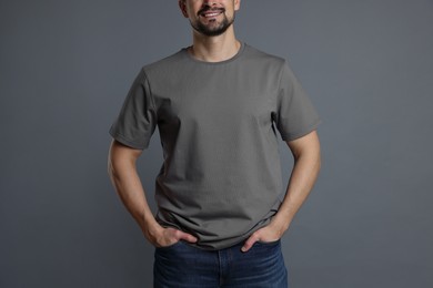 Photo of Man in blank t-shirt on grey background, closeup. Mockup for design