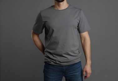 Photo of Man in blank t-shirt on grey background, closeup. Mockup for design