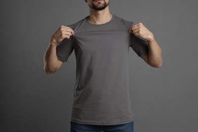 Photo of Man in blank t-shirt on grey background, closeup. Mockup for design