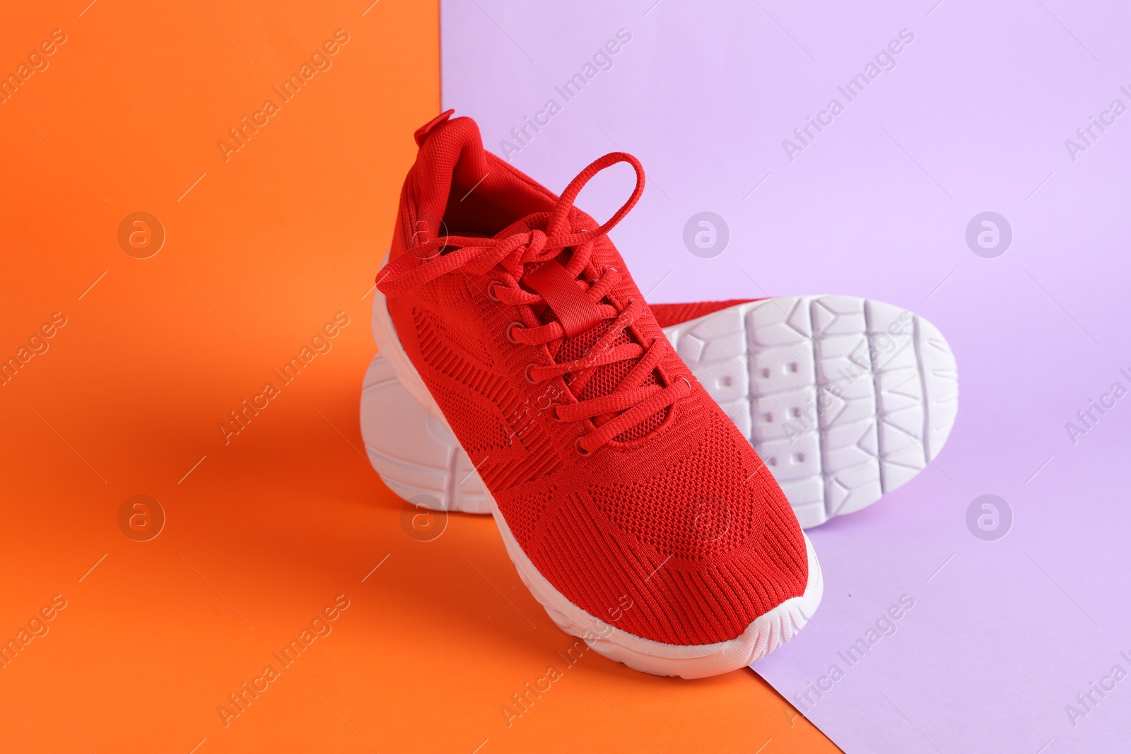 Photo of Pair of stylish red sneakers on color background