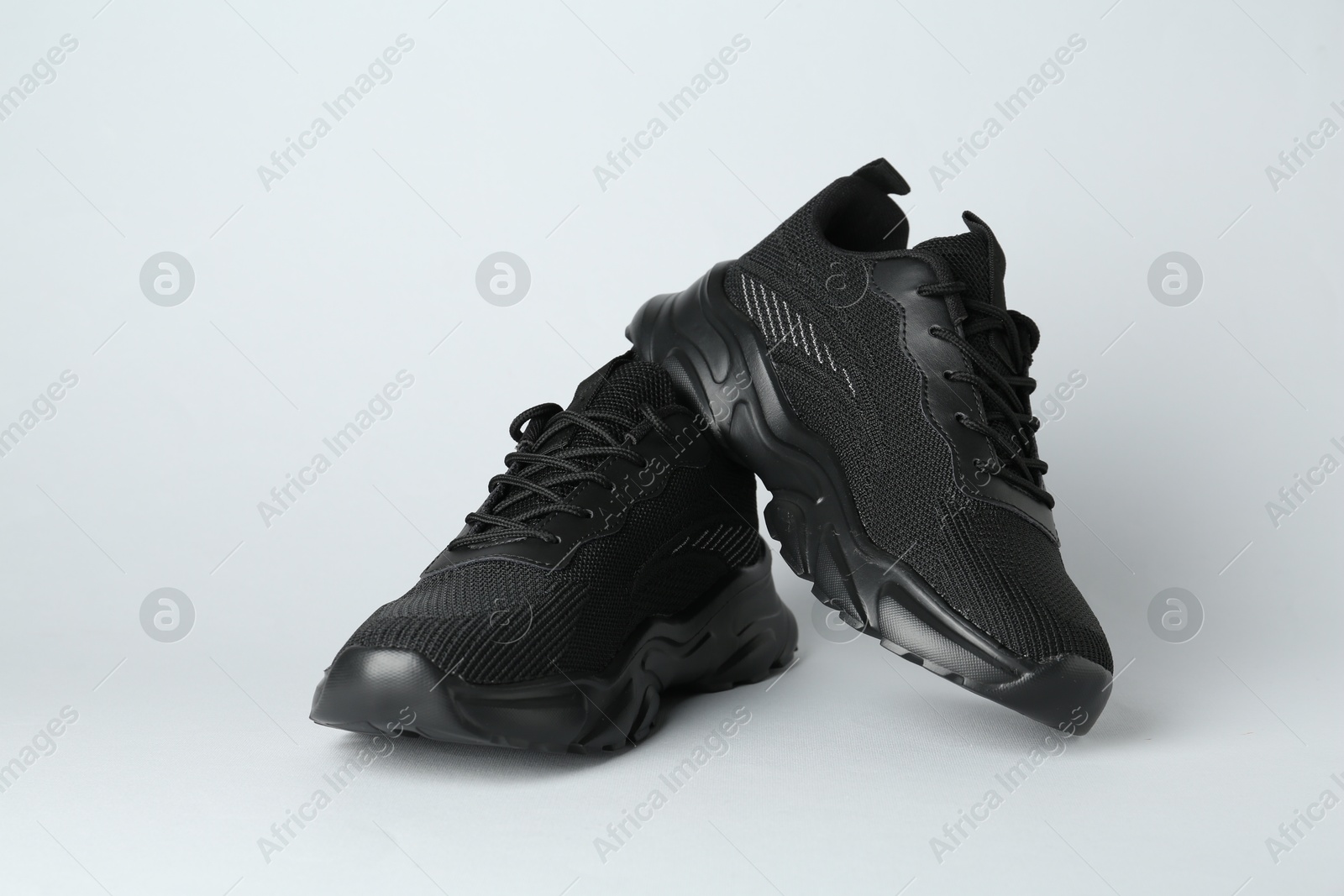 Photo of Pair of stylish black sneakers on white background