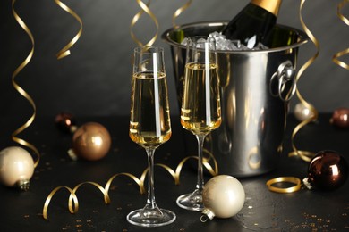 Photo of Champagne in glasses and decor on black table. Christmas celebration