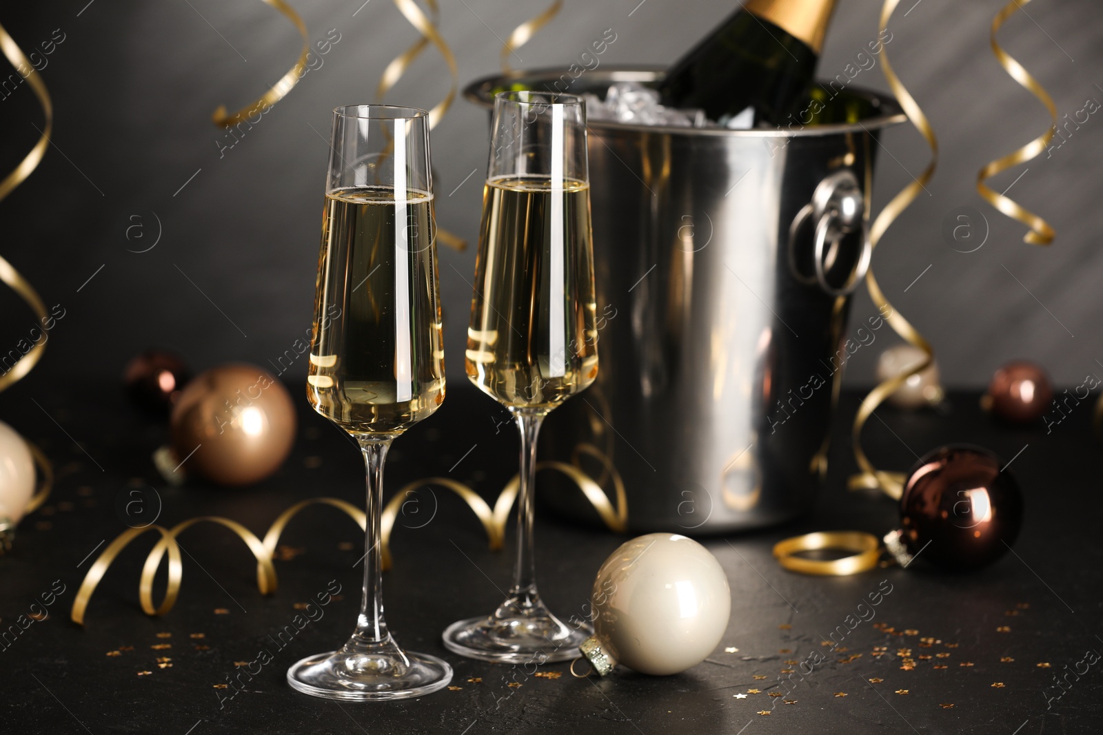 Photo of Champagne in glasses and decor on black table. Christmas celebration