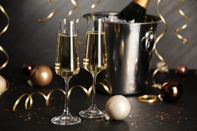 Photo of Champagne in glasses and decor on black table. Christmas celebration