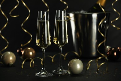 Photo of Champagne in glasses and decor on black table. Christmas celebration