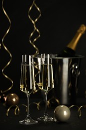 Photo of Champagne in glasses and decor on black table. Christmas celebration