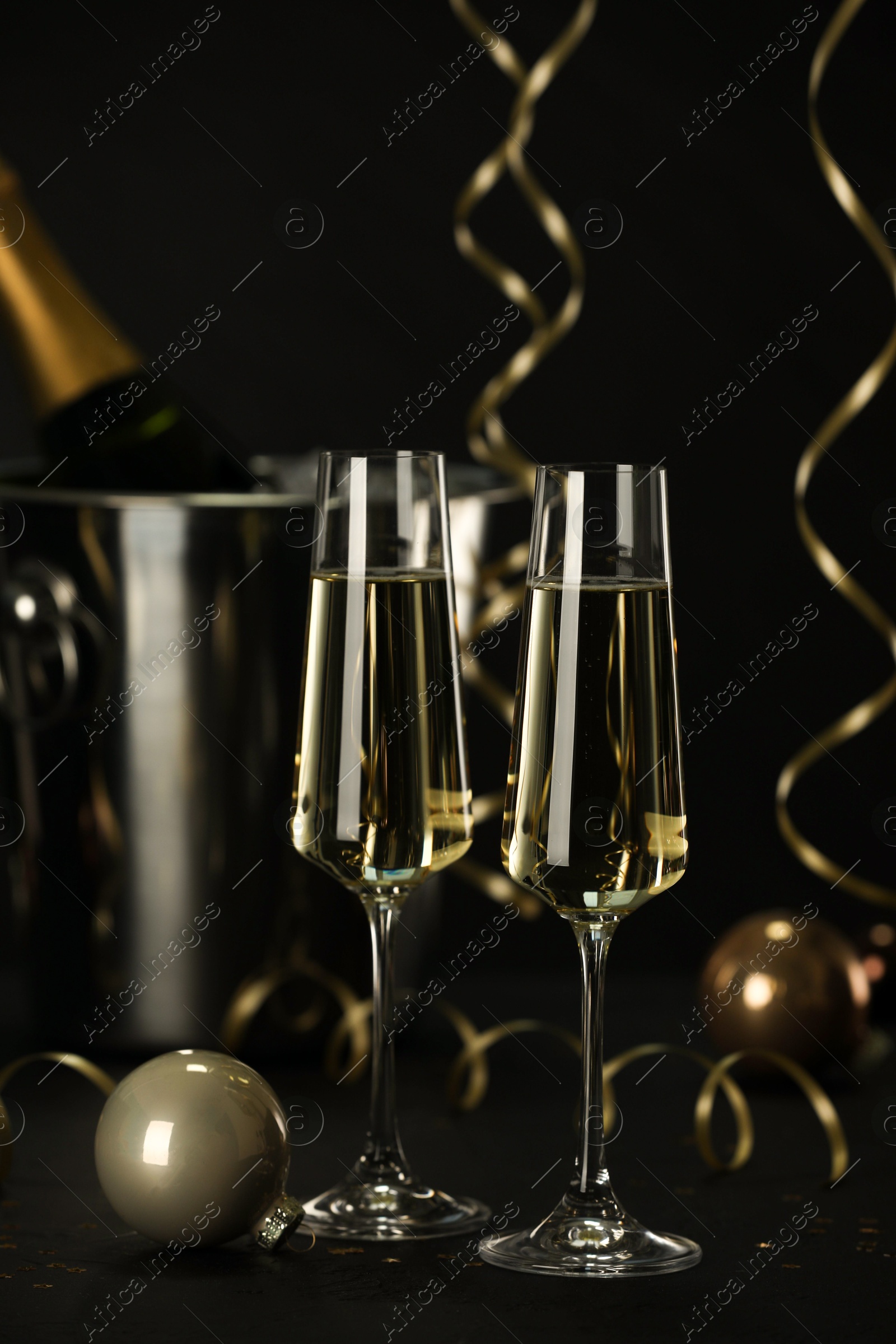 Photo of Champagne in glasses and decor on black table. Christmas celebration