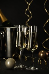 Photo of Champagne in glasses and decor on black table. Christmas celebration