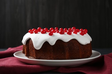 Photo of Tasty Christmas cake with red currants on table against dark background, closeup