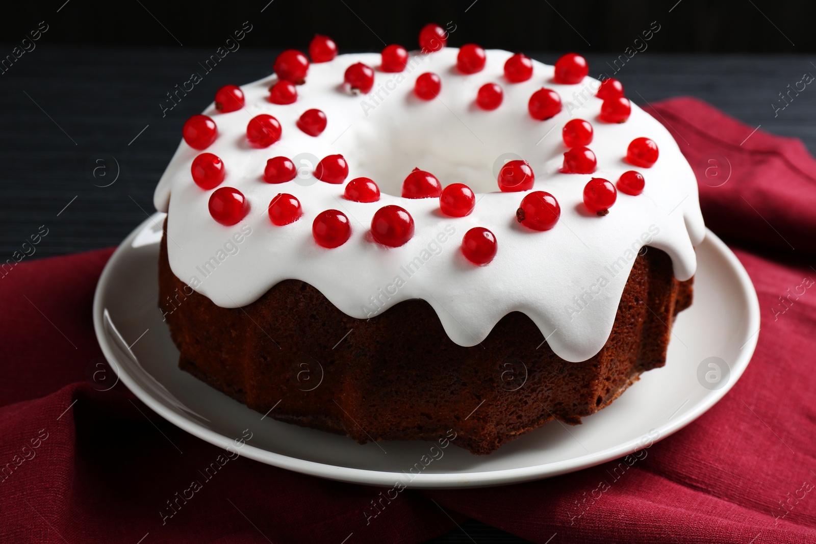 Photo of Tasty Christmas cake with red currants on table, closeup