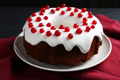 Photo of Tasty Christmas cake with red currants on table, closeup