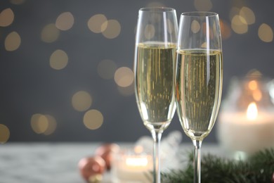 Photo of Delicious champagne in glasses against blurred lights, closeup with space for text. Christmas celebration