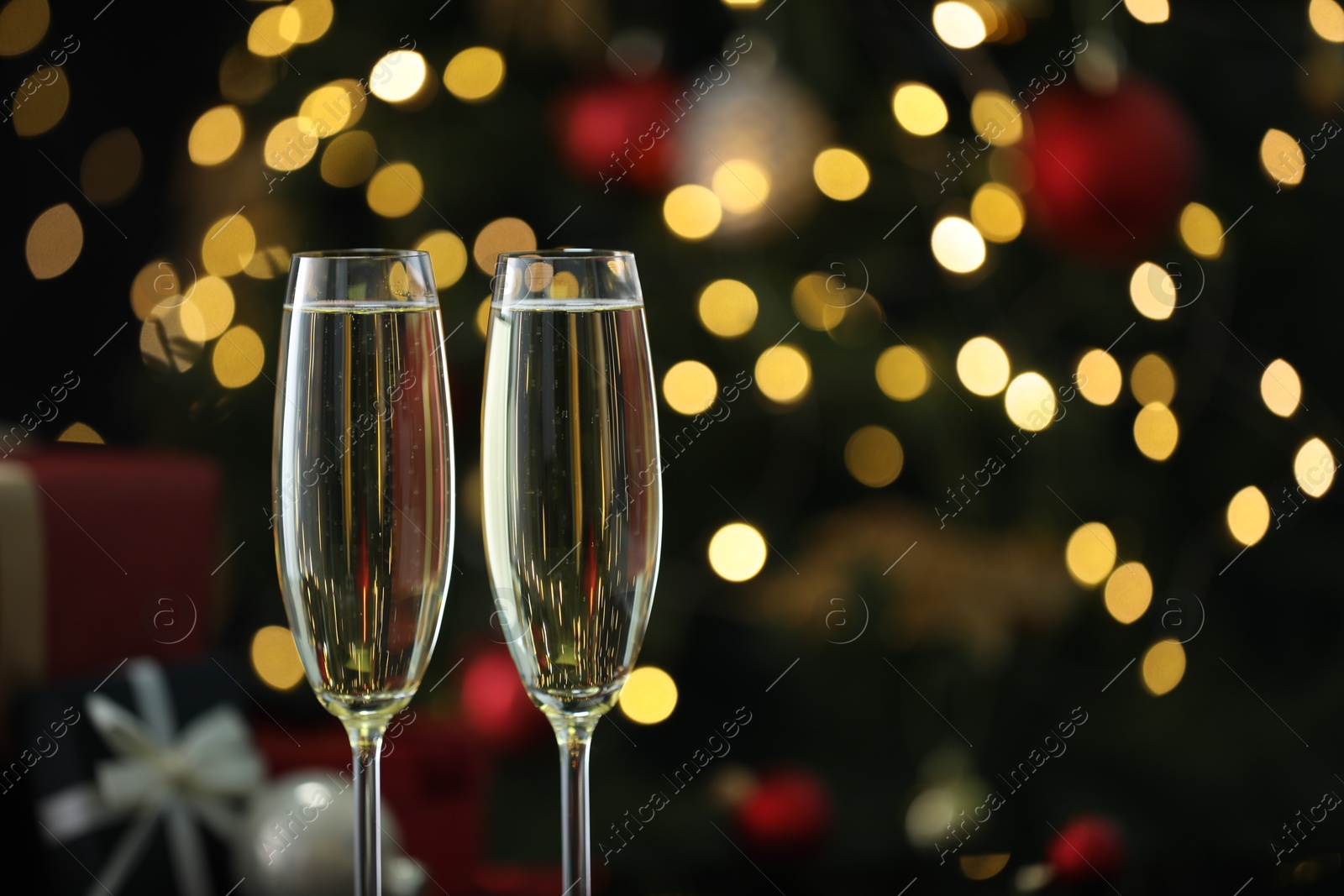 Photo of Delicious champagne in glasses against blurred lights, closeup with space for text. Christmas celebration