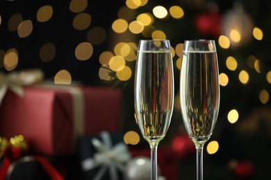 Photo of Delicious champagne in glasses against blurred lights, closeup with space for text. Christmas celebration