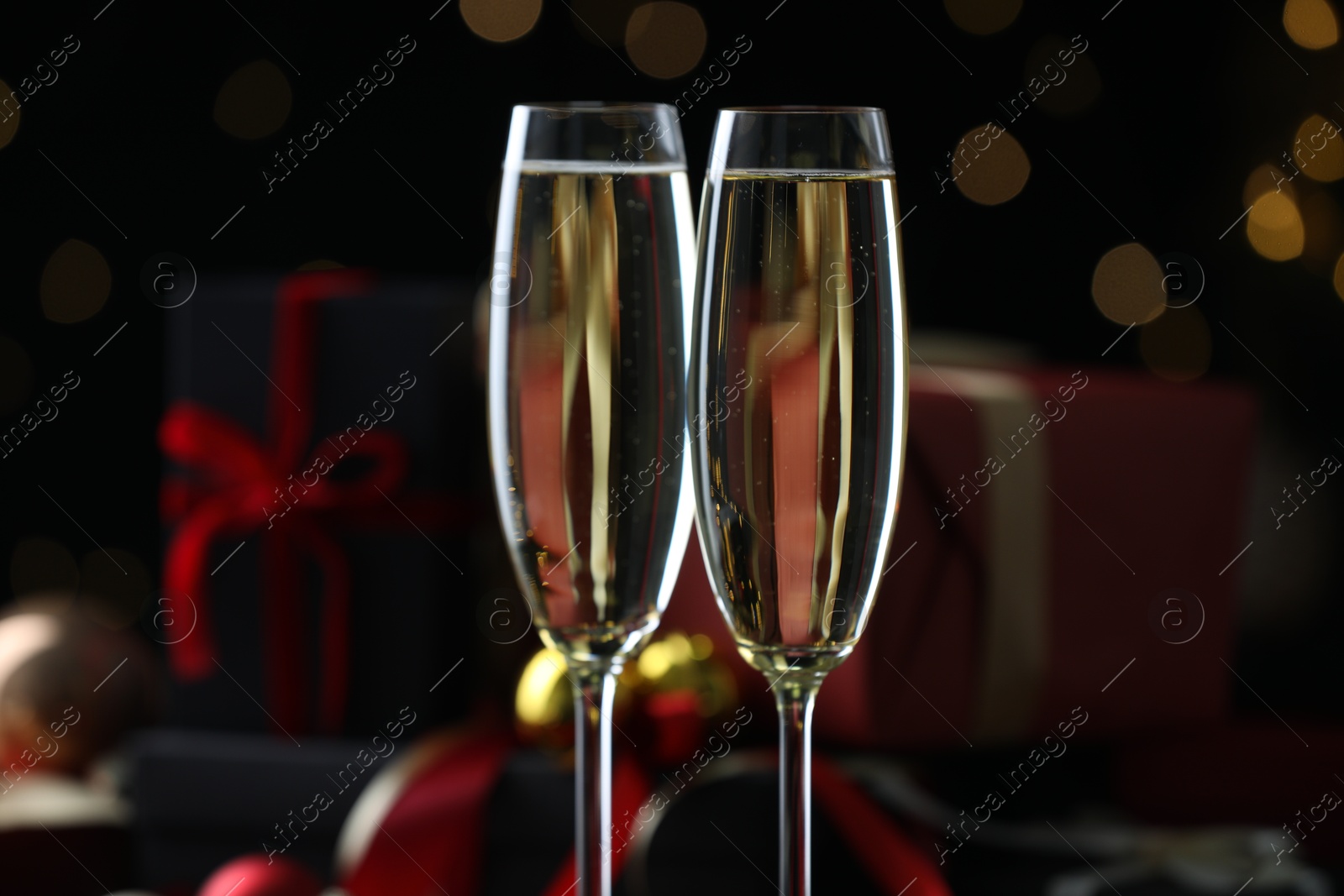 Photo of Delicious champagne in glasses against blurred lights, closeup. Christmas celebration