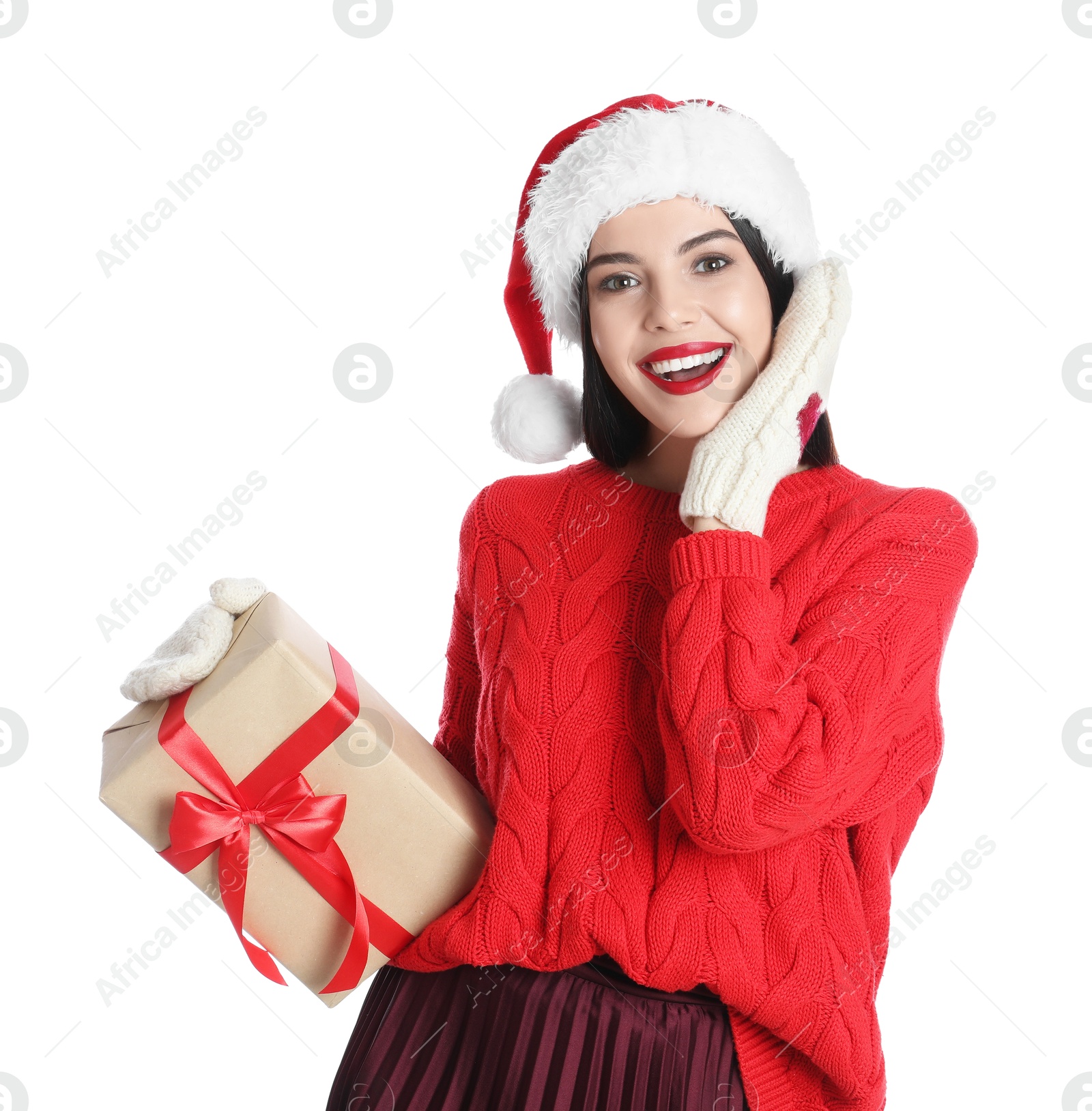 Photo of Woman in Santa hat, knitted mittens and red sweater holding Christmas gift on white background