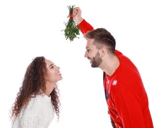 Photo of Lovely couple under mistletoe bunch on white background