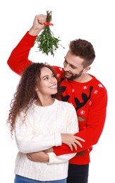 Lovely couple under mistletoe bunch on white background