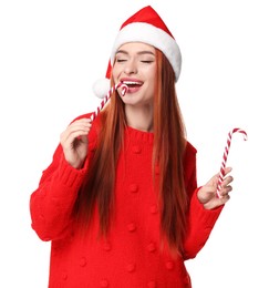 Photo of Young woman in red sweater and Santa hat with candy canes on white background. Christmas celebration