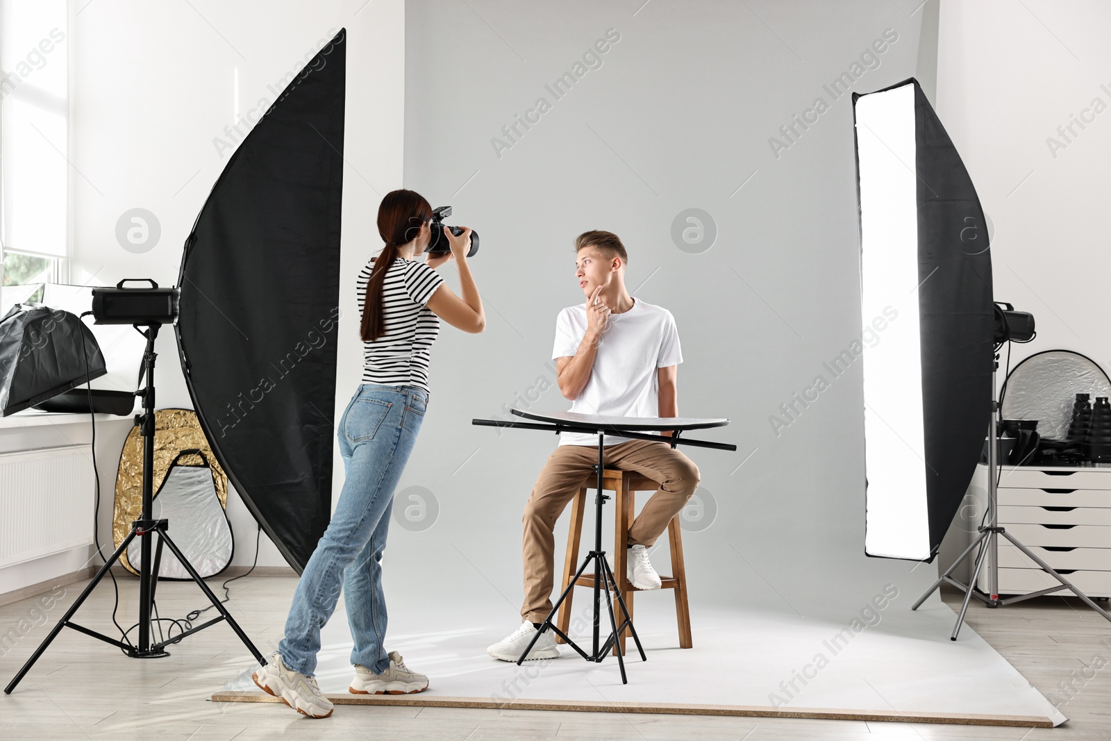 Photo of Photographer working with model in professional photo studio