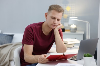 Photo of Student preparing for exam at table indoors