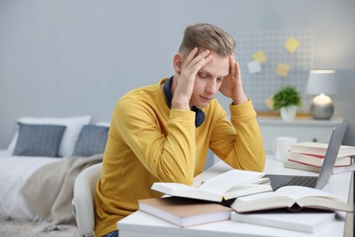 Photo of Student preparing for exam at table indoors