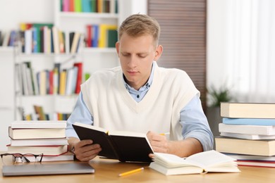 Photo of Student preparing for exam at table indoors